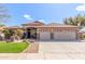 Charming single-story home showcasing a well-manicured lawn, desert landscaping, and a spacious three-car garage at 5929 W Riviera Dr, Glendale, AZ 85304