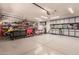 Large garage with extensive cabinetry, ample workspace, and epoxy floors at 5929 W Riviera Dr, Glendale, AZ 85304