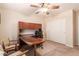 Functional home office with built-in desk, shelving, a ceiling fan, and sliding closet doors at 5929 W Riviera Dr, Glendale, AZ 85304