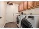 Functional laundry room with washer, dryer, and storage cabinets above at 5929 W Riviera Dr, Glendale, AZ 85304