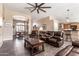 Spacious living room with leather furniture, ceiling fan, and views to the dining and kitchen areas at 5929 W Riviera Dr, Glendale, AZ 85304