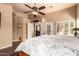 Spacious main bedroom features a ceiling fan, shuttered windows, and a view into the living room at 5929 W Riviera Dr, Glendale, AZ 85304