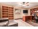 Spacious office featuring built-in bookshelves, desk, and comfortable seating area at 5929 W Riviera Dr, Glendale, AZ 85304