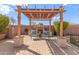 Outdoor pergola seating area with patterned chairs and decorative lighting at 5929 W Riviera Dr, Glendale, AZ 85304