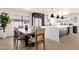 Modern dining area with a wooden table, upholstered chairs, and an adjacent kitchen at 6759 E Aire Libre Ln, Scottsdale, AZ 85254