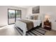 Bright main bedroom with a sliding door, modern decor, and a stylish striped rug at 6759 E Aire Libre Ln, Scottsdale, AZ 85254