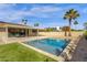 Backyard oasis featuring a sparkling pool, patio, palm trees, and low-maintenance landscaping at 6759 E Aire Libre Ln, Scottsdale, AZ 85254