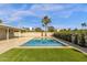 An outdoor pool area surrounded by lush green grass and palm trees, perfect for leisure and relaxation at 6759 E Aire Libre Ln, Scottsdale, AZ 85254