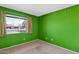 Bedroom with neutral carpet, light switches, and a view to the outside at 6824 N 31 Ave, Phoenix, AZ 85017