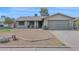 Single-story home featuring a two-car garage and a desert landscape at 6824 N 31 Ave, Phoenix, AZ 85017