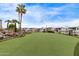 Scenic putting green with palm trees, rock waterfall, and lush turf, offering a resort-style amenity at 7750 E Broadway Rd # 843, Mesa, AZ 85208