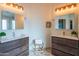 Bathroom with dual sink vanity, decorative mirrors and modern lighting fixtures above at 7826 W Kerry Ln, Glendale, AZ 85308