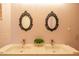 Bathroom with dual sinks, tile floors, ornate mirrors, and a floral arrangement at 7826 W Kerry Ln, Glendale, AZ 85308