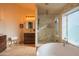 Bright bathroom featuring a soaking tub, glass shower, travertine tile, and wooden vanity at 7826 W Kerry Ln, Glendale, AZ 85308