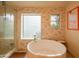 Modern bathroom with a sleek bathtub, glass-enclosed shower, and natural lighting at 7826 W Kerry Ln, Glendale, AZ 85308