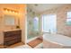 Luxurious bathroom featuring a modern vanity, glass shower, and standalone soaking tub with warm lighting at 7826 W Kerry Ln, Glendale, AZ 85308