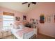 Bright bedroom with a pink color scheme, including a fluffy blanket, pillows and wall decor at 7826 W Kerry Ln, Glendale, AZ 85308