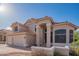 Attractive two-story home with arched windows, a tile roof, desert landscaping, and a welcoming front porch at 7826 W Kerry Ln, Glendale, AZ 85308