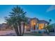 Inviting home exterior with palm trees, a well-maintained lawn, and warm exterior lighting at 7826 W Kerry Ln, Glendale, AZ 85308