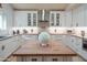 Bright kitchen featuring white cabinets, tile backsplash, granite counters, and a central island with a wooden countertop at 7826 W Kerry Ln, Glendale, AZ 85308