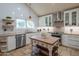 Open kitchen featuring white cabinets, stainless steel appliances, granite countertops, and a central wood island at 7826 W Kerry Ln, Glendale, AZ 85308