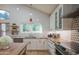 Bright kitchen featuring white cabinets, granite countertops, stainless appliances, and a view to the backyard at 7826 W Kerry Ln, Glendale, AZ 85308