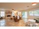 Spacious living room featuring tile flooring, a brick fireplace, and an abundance of natural light at 7826 W Kerry Ln, Glendale, AZ 85308