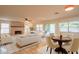 Open-concept living space with a cozy fireplace, comfortable seating, and a dining area flooded with natural light at 7826 W Kerry Ln, Glendale, AZ 85308
