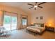 Spacious main bedroom with vaulted ceiling, bench seating, ceiling fan, and sliding glass doors at 7826 W Kerry Ln, Glendale, AZ 85308