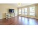 Bedroom featuring wood floors, ceiling fan, and a TV on a storage console with backyard views at 908 E Mountain Sage Dr, Phoenix, AZ 85048