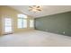 Spacious living room with carpeted floors, an exit to the outside, and two bright, large windows at 908 E Mountain Sage Dr, Phoenix, AZ 85048