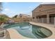 Beautiful backyard pool with rock waterfall, multi-level patio, and lush landscaping at 908 E Mountain Sage Dr, Phoenix, AZ 85048