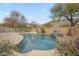 Inviting pool with rock feature and landscaping, perfect for relaxation and outdoor entertainment at 908 E Mountain Sage Dr, Phoenix, AZ 85048