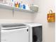 Functional laundry room showcasing a modern washer and dryer with convenient shelving at 913 E Tekoa Ave, Gilbert, AZ 85298