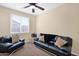 Inviting living room featuring leather sofas, plush carpet, a ceiling fan, and natural light at 913 E Tekoa Ave, Gilbert, AZ 85298