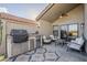 Inviting covered patio with a built-in outdoor kitchen including grill and fridge and cozy seating area at 9409 W Taro Ln, Peoria, AZ 85382