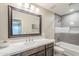 Stylish bathroom featuring a large mirror, modern vanity, and a shower-tub combination at 9409 W Taro Ln, Peoria, AZ 85382