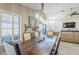 Bright dining room featuring a wooden table, stylish lighting fixture, and views of the backyard at 9409 W Taro Ln, Peoria, AZ 85382