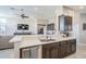 Open concept kitchen featuring gray cabinets, stainless appliances, and a breakfast bar overlooking the living area at 9409 W Taro Ln, Peoria, AZ 85382