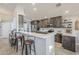 Bright kitchen featuring gray cabinets, stainless appliances, a breakfast bar, and neutral tile flooring at 9409 W Taro Ln, Peoria, AZ 85382