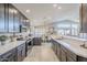 Spacious kitchen featuring gray cabinets, stainless appliances, tile floors, and a large island at 9409 W Taro Ln, Peoria, AZ 85382