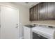 Efficient laundry room with dark wood cabinets and modern appliances, providing convenience at 9409 W Taro Ln, Peoria, AZ 85382