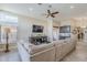 Open-concept living room with a large sectional, media console, and access to the kitchen and bar area at 9409 W Taro Ln, Peoria, AZ 85382