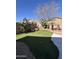 Backyard featuring a putting green and desert landscaping including cacti, palms, and brick accents at 9632 W Runion Dr, Peoria, AZ 85382