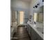 Bathroom featuring a double sink vanity, quartz countertops, framed mirrors, and modern lighting at 9632 W Runion Dr, Peoria, AZ 85382