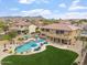 An aerial shot of the home showing the pool, patio, lush green yard, desert landscaping and picturesque mountain views at 9686 W Keyser Dr, Peoria, AZ 85383