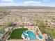 Drone shot of the backyard with a pool, desert landscape, firepit, patio and mountain views beyond at 9686 W Keyser Dr, Peoria, AZ 85383