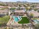 Backyard features a sparkling pool, lush lawn, covered patio, and stunning views of the surrounding area at 9686 W Keyser Dr, Peoria, AZ 85383