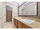 Traditional bathroom with dual sinks, tile floors, and an alcove shower with a neutral-colored curtain at 9686 W Keyser Dr, Peoria, AZ 85383