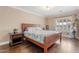 Bright bedroom featuring hardwood floors, a cozy bed, nightstand, and a large shuttered window for natural light at 9686 W Keyser Dr, Peoria, AZ 85383